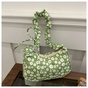 Detail of green floral shoulder bag with white daisy prints and scrunchie handle strap