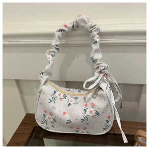 Close-up of floral tote bag with distinctive ruched handle and side bow knot detail
