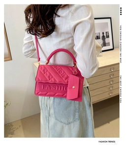 Rear view of bright pink crossbody bag with FASHION embossing and quilted texture