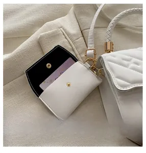 Detail of white quilted crossbody bag with matching card holder on professional attire