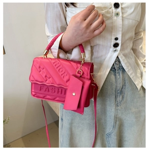 Detail of rose pink textured crossbody bag with Fashion logo and small coin purse