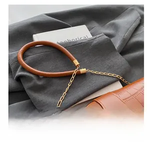 Detail of brown crocodile embossed bag with padded shoulder strap and gold T-shaped clasp