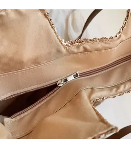 Détail de la fermeture éclair en métal et de la doublure en tissu du sac en paille