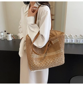 Détail du grand sac cabas tissé en paille avec motif ondulé blanc et lanières en cuir