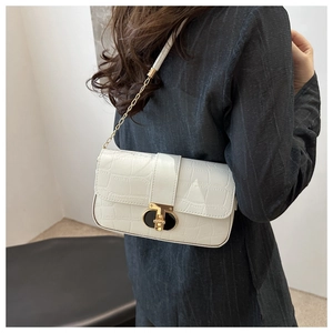Close-up of white crocodile pattern shoulder bag with elegant gold chain strap