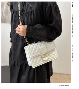 Detailansicht der weißen Steppledertasche mit elegantem goldenem V-Form Metallverschluss