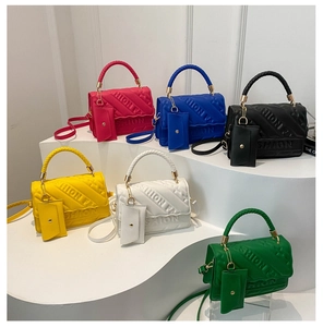 Detail view of stylish quilted handbags in six vibrant colors with woven handles and small charms