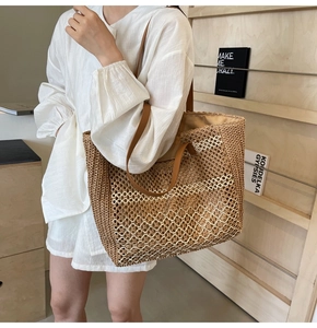 Détail du sac cabas en paille tissée avec anses en cuir marron et motif de vagues