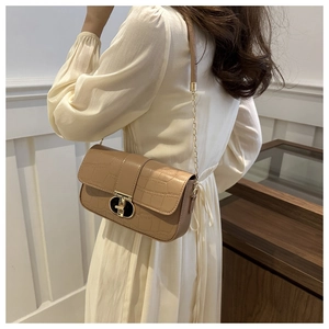 Detailed side view of beige crocodile embossed shoulder bag with gold chain strap