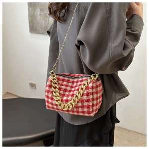 Détail du mini sac polochon à carreaux rouges avec chaîne dorée et fermeture éclair