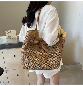 Détail du sac cabas en paille tressée avec motif en maille et lanières en cuir marron