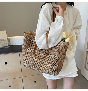 Détail d'un sac fourre-tout tissé main montrant les motifs en paille et anses en cuir