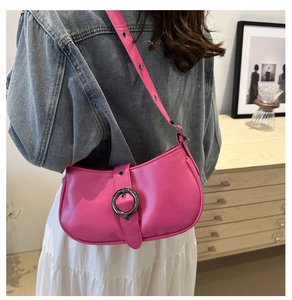 Dettaglio di una borsa a spalla rosa acceso con grande fibbia in metallo e pelle sintetica lucida