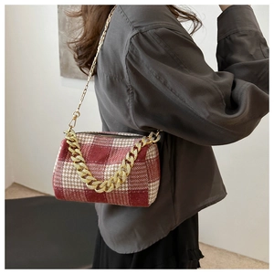 Vue mannequin d'un sac cylindrique en tweed à carreaux rouge et blanc avec chaîne