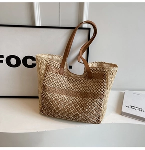 Gros plan du sac cabas en paille tissée avec rayures contrastées et anses en cuir brun