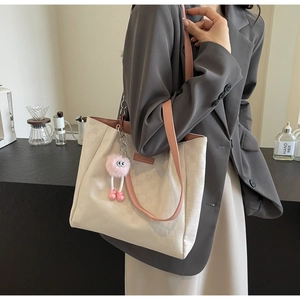Detail of checkered embossed tote bag with pink leather strap and fashion label