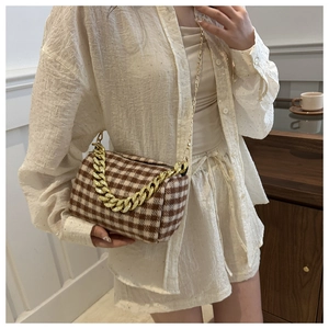 Détail du sac bandoulière à motif pied-de-poule avec chaîne dorée élégante et chic