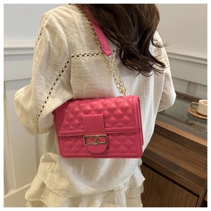 Detailansicht der pinkfarbenen Stepptasche mit Herzmuster und goldener Hardware-Kette