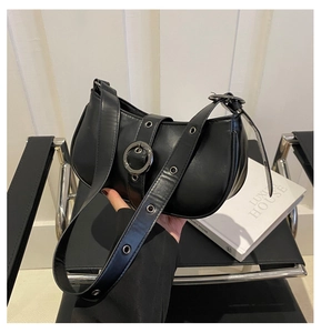 Dettaglio borsa hobo a mezzaluna nera con fibbia metallica e tracolla con occhielli