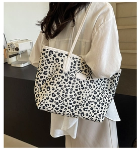 Sac fourre-tout à motif léopard avec fines bretelles blanches porté par un mannequin femme