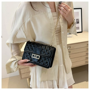 Schwarze Stepptasche mit goldener Kette am Model zur Darstellung von Größe und Passform