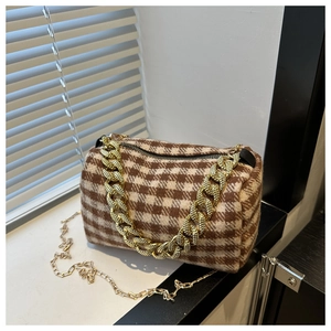 Détail du sac cylindre vintage à motif pied-de-poule avec chaîne dorée et laine