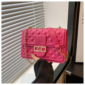 Detail der rosaroten Stepptasche mit goldener V-Schnalle und Metallkettenriemen