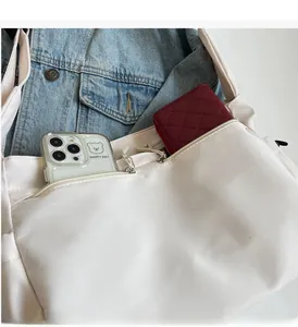 Detail view of white nylon tote bag with functional double zipper pockets for storage