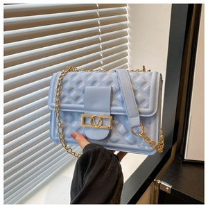Nahaufnahme der hellblauen Stepptasche mit goldenem V-Verschluss und Kettenriemen