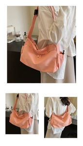 Detail showing peach pink tote bag with wide strap and side storage pockets for women