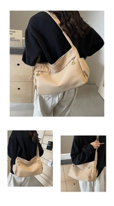 Detailed side view of beige nylon crossbody bag featuring stylish triangular metal zipper