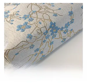 Close-up of jacquard fabric with blue floral patterns and gold thread on a luxury bag
