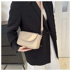 Chic beige shoulder bag on female model in stylish suit for casual daily fashion look