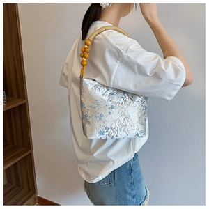 Detail of Chinese style silk embroidery bucket bag with vintage wooden beads and floral patterns