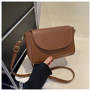 Close-up of caramel brown crossbody bag with gold hardware and adjustable strap detail