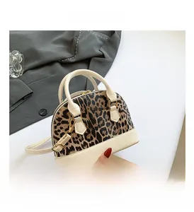 Top view of a leopard print handbag with cream leather trim and gold hardware accents