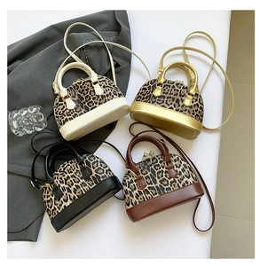 Detail view of four mini leopard print shell bags in beige gold black and brown leather
