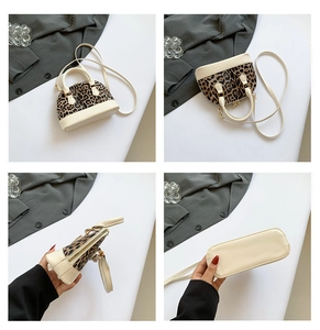 Detail view of leopard print shell bag showing stitching, zippers and metal feet