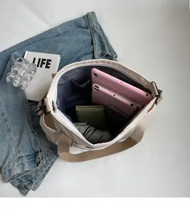 Detail view of large interior space for tablet and daily items in beige nylon tote