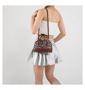 Detail of leopard print shell bag with brown leather handles and gold metal hardware