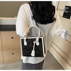 Sac à main bicolore noir et blanc avec texture marbre et bandoulière amovible