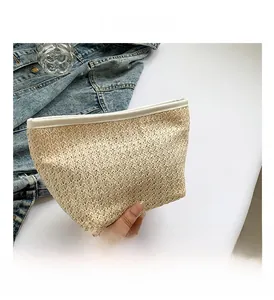 Dettaglio di borsa in paglia intrecciata con finiture in pelle PU bianca e beige