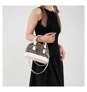 Close-up of leopard print shell bag featuring white leather trim and metal zipper