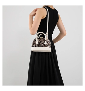 Detailed back view of leopard print shell bag with adjustable strap on black dress