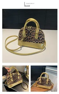 Detail view of the gold handle and leopard print material on the shell shaped handbag