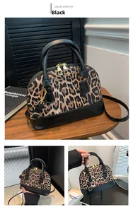 Detail of leopard print shell bag with black leather straps and gold zipper closure