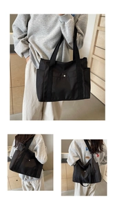 Detail of a large black nylon tote bag showing spacious pockets and silver metal buttons