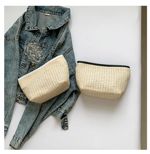 Dettaglio di pochette in paglia intrecciata con texture naturale e bordi a contrasto
