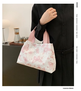 Détail du sac seau blanc avec motifs papillons roses et anses en tissu contrastées