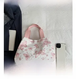Comparaison détaillée du sac cabas blanc imprimé papillon rose à côté d'un smartphone